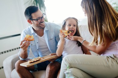 Mutlu aile birlikte evde pizza paylaşımı gülümseyen