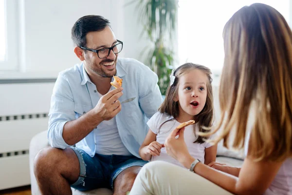 Happy smiling family sharing pizza together at home