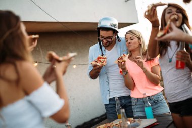 Bir grup genç insan çevresinde oturan ve pizza yemek. Parti ve pizza yemek arkadaşlar.