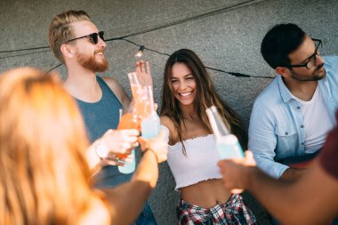 Friends having fun and drinking cocktails outdoor on a rooftop get together