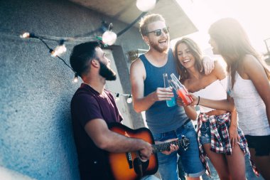 Arkadaşlar eğlenmeye ve kokteyller açık bir çatıda içme bir araya