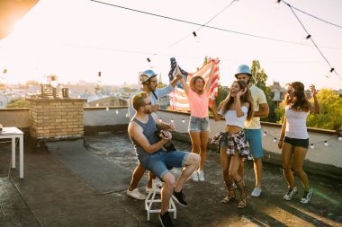 Bir grup arkadaş çatıdaki partide eğleniyor..