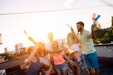 Bir grup arkadaş çatıdaki partide eğleniyor..