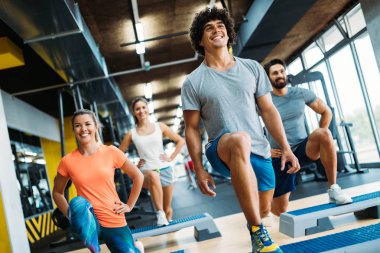 Bir grup genç insan birlikte spor salonunda yapıyor