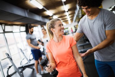 Spor salonunda antrenörle çalışan güzel bir kız.