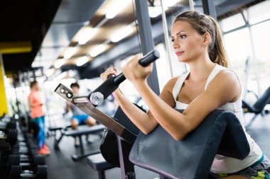 Spor salonunda fitness makine üzerinde çalışan kadın