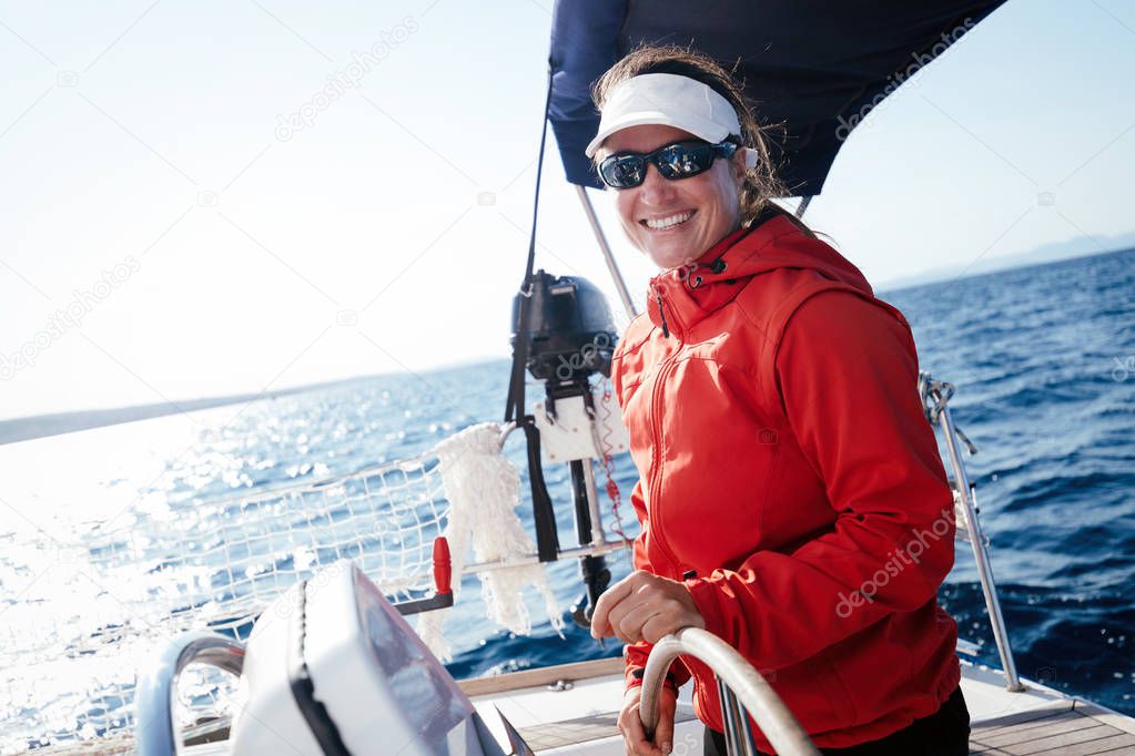 Attractive strong woman sailing with her sail boat