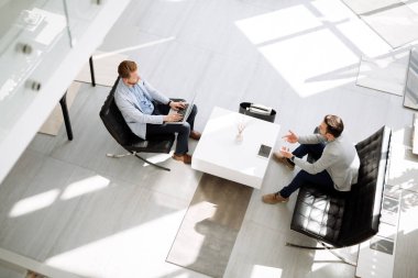 Ofis lobisinde fikirleri tartışmak iş adamları