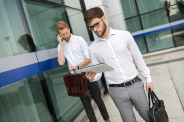 Açık havada yürüyüş ve kullanarak iş adamları telefonları Tablet