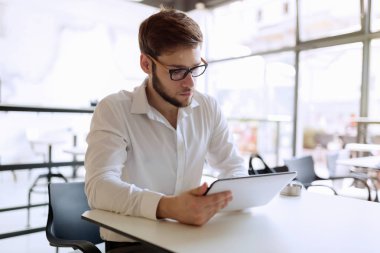 Kafede tablet üzerinde çalışan emin meşgul işadamı