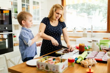 Güzel çocuk ve anne sevgi ile mutfakta pişirme