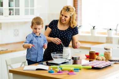 Güzel çocuk ve anne sevgi ile mutfakta pişirme