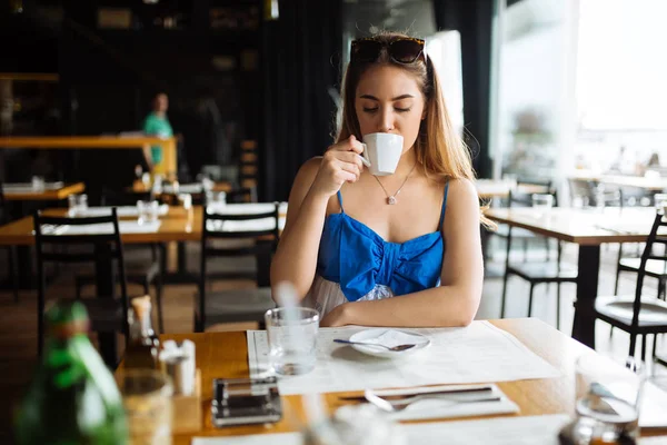 Stunning woman enjoying her coffee in restaurant
