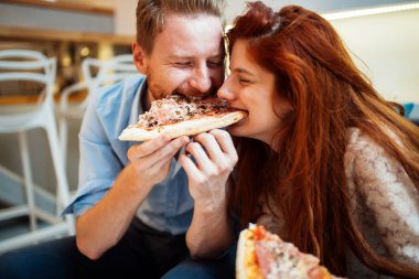 Çift pizza paylaşımı ve birlikte mutlu bir şekilde yemek