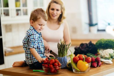 Anne ve çocuk taze sebzeler yemekten hazırlanıyor