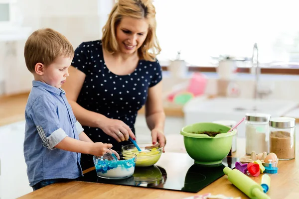 Güzel çocuk ve anne sevgi ile mutfakta pişirme