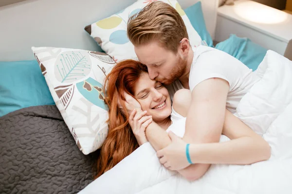 Çift birbirlerine yatakta yatan süre öpüşme sarılma aşık