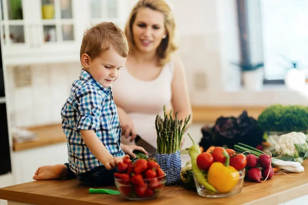 Anne ve çocuk taze sebzeler yemekten hazırlanıyor