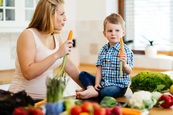 Hamile kadın oğlundan taze sebze ile yemek hazırlama