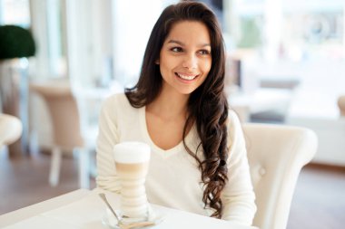 Güzel bir genç esmer kahve içme kafede portresi