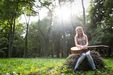 Güzel kadın doğada akustik gitar çalmak