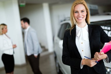 Araç showroom içinde duran güzel genç pazarlamacı portresi