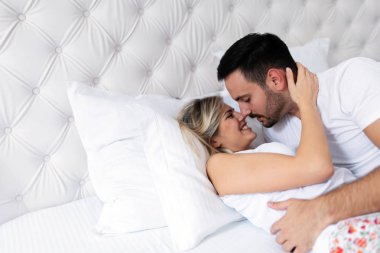 Mutlu genç çift yatak odasında romantik anlar yaşıyor.