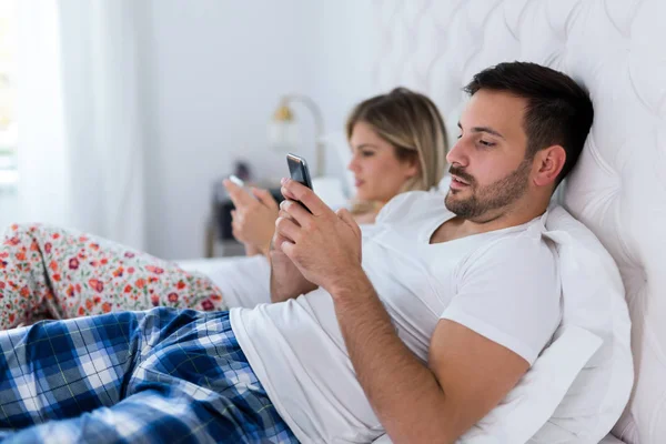 Image Jeune Couple Ennuyé Dans Chambre Coucher Utilisant Des Téléphones — Photo