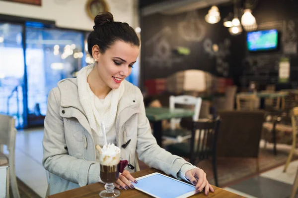 Attractive young woman using digital tablet in cafe