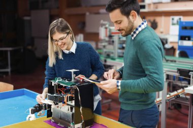 Mekatronik projede birlikte çalışan genç çekici öğrenci