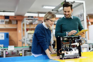 Mekatronik projede birlikte çalışan genç çekici öğrenci