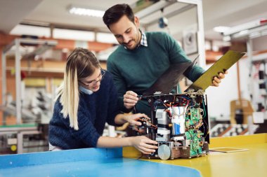 Mekatronik projede birlikte çalışan genç çekici öğrenci