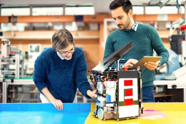 Mekatronik projede birlikte çalışan genç çekici öğrenci