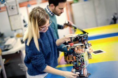 Mekatronik projede birlikte çalışan genç çekici öğrenci