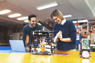 Mekatronik projede birlikte çalışan genç çekici öğrenci