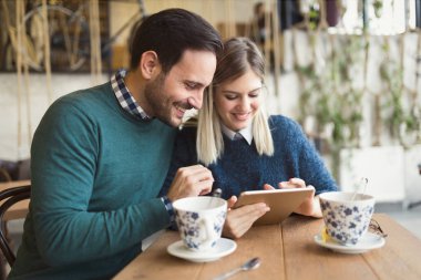 Genç çekici çift dijital tablet kahve dükkanında kullanma