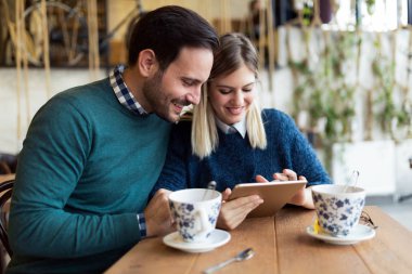 Genç çekici çift dijital tablet kahve dükkanında kullanma