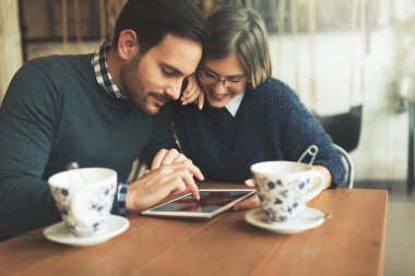 Genç çekici çift dijital tablet kahve dükkanında kullanma