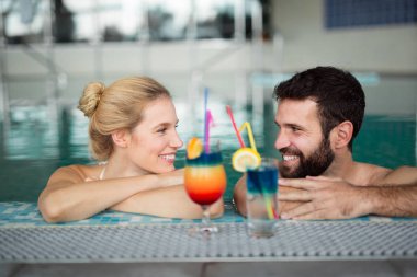 Mutlu çift birlikte spa merkezinde yüzme havuzunda zevk.