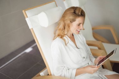 Rahatlatıcı ve spa merkezinde tablet kullanarak güzel kadın resim