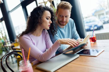 Kitap okuma ve konuşuyor genç çekici öğrenci portresi