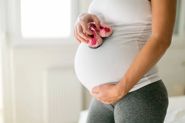 Έγκυος Γυναίκα Κρατώντας Παπούτσια Κορίτσι Μωρό Στην Κοιλιά Της — Φωτογραφία Αρχείου