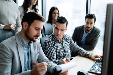 Modern ofis içinde bilgisayar üzerinde çalışan genç iş adamları
