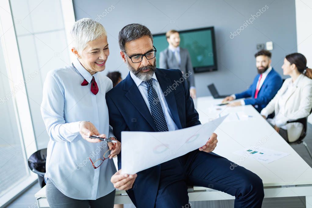 Portrait of happy business people discussing together in modern office