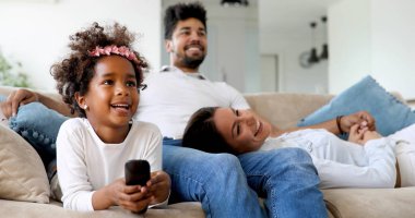 Genç sevimli kız ailesiyle birlikte TV izlerken
