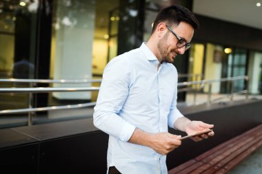 Eldeki güncel kalmak için tablet ve telefon sürekli sahip iş adamı