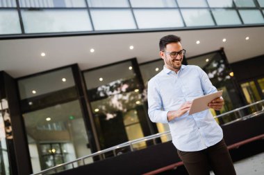 Tablet açık havada tutan bardaklarda işadamı portresi