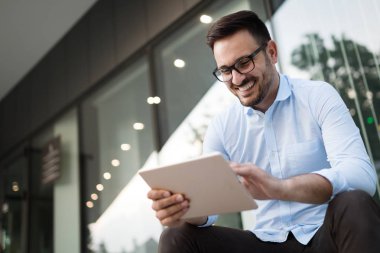 Tablet açık havada tutan bardaklarda işadamı portresi