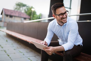 Eldeki güncel kalmak için tablet ve telefon sürekli sahip iş adamı