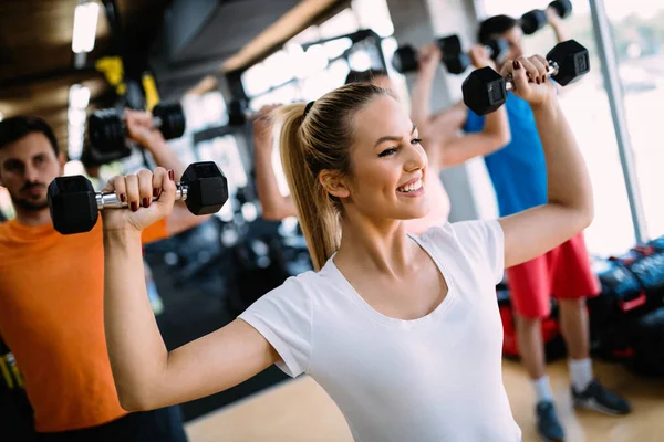 Güzel genç kadının omuz içinde jimnastik salonu için egzersizler yapması